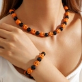 Set gioielli Halloween con perline a teschio arancioni e nere indossato da una modella - Set Collana Bracciale Scheletro Arancione Nero (30440-NB-set-ob)