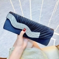 Dettaglio di un'elegante pochette da sera in seta nera con lussuosi strass a forma di W - Nero