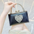 Makroaufnahme einer eleganten schwarzen Abendtasche mit funkelndem Herz-Strass-Detail - Schwarz