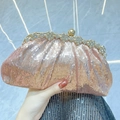 Elegant rose gold sequin clutch bag with crystal flower clasp held against marble - Pink