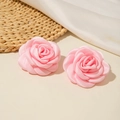 Détail de boucles d'oreilles roses en satin sur paille tressée et tissu blanc - Rose