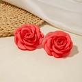 Gros plan sur des boucles d'oreilles camélia en soie rouge avec des pétales en tissu satiné - Rouge