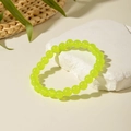 Vibrant lime green translucent beaded bracelet on white stone with floral accents - Green