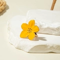 Macro shot of yellow five-petal flower ring with gold trim on white stone surface - Yellow Five-Petal Flower