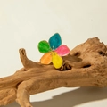 Macro detail of a colorful enamel five-petal flower ring on natural driftwood background - Colorful Five-Petal Flowers