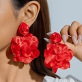 Close-up of handmade red fabric rose earrings with layered satin petals and vivid texture - Red