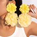 Detail of yellow chiffon flower earrings showing layered petals on a fashion model - Lemon Yellow