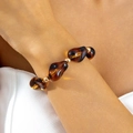 Exaggerated amber acrylic beaded bracelet set with gold metal accents on model wrist - Amber Irregular Large Bead Bracelet (31707)