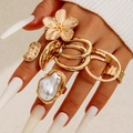 Set di anelli dorati con fiori e perle con finitura martellata su mano femminile - Set Martellato Fiori di Perle (30365-ring-G) / Oro