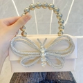 Elegant champagne silk evening clutch with a sparkling rhinestone bow and bead handle - Champagne