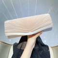 Elegante champagnerfarbene Satin-Abendtasche mit Falten, gehalten von einem Model - Aprikose