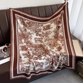 Classic Toile de Jouy tiger print silk square scarf elegantly draped over a leather sofa - Coffee