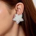 Orecchini a stella alla moda con perle e strass indossati sull'orecchio della modella - Stile Stella Bianca (28351-ear-white-4)