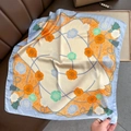 Detalle de pañuelo cuadrado de seda con estampado floral y borlas verdes en cuero - Azul