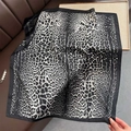 Close-up of leopard print silk scarf with black border on brown leather surface - Black / 70cmx70cm