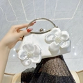 White satin evening bag with 3D silk flowers and pearl details featuring gold metal handles - White