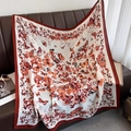 Detail of butterfly print square scarf on leather sofa with elegant accessories - Caramel Edge