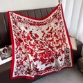 Floral butterfly print square silk scarf for women in cream and red draped on sofa - Red