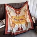 Lussuoso foulard in seta con stampa equestre arancio e bordeaux su divano in pelle - Bordo Nero
