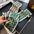Dettaglio della sciarpa in seta Twilly geometrica con etichetta 100% poliestere visibile - 12*145cm / Verde