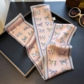 Macro view of a pink horse print silk twilly scarf with deep gray borders on a tray - Pink (ZJ-209)