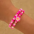 Pulseras bohemias de cuentas heishi rosas y blancas con un dije de flor de plumeria en la muñeca - Juego Rosa (29909-rose)
