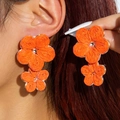Handmade orange raffia flower earrings with golden centers in bohemian beach style - Bright Orange