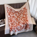 Detailed pattern of orange and beige polka dot silk scarf featuring camellia flower prints - Orange