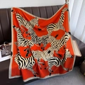 Detailed view of an orange zebra-print silk shawl spread on a premium leather sofa - 90*90cm / Orange (HSM-56)