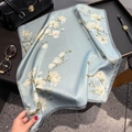Elegant light blue silk scarf with white magnolia pattern on a premium black handbag - 53x53cm / Blue