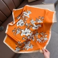 Elegante foulard quadrato in seta arancione con motivi floreali su pelle marrone - Stile Sciarpa / Arancione