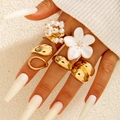 Golden 5-piece ring set featuring baroque pearls and white enamel flower on a model hand - Gold Enamel Floral Pearl Style (30268-ring-G white) / 5 Pieces / Gold