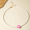 Dettaglio collana di perle con ciondolo a fiore di frangipane e chiusura dorata - Rosso Rosa (29919-nek-ros)
