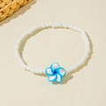 Close-up of handmade white beaded anklet with blue and white plumeria flower pendant - Blue Frangipani Style