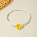 Detail of beaded anklet with white beads and a yellow plumeria flower pendant for summer - Yellow Frangipani Style