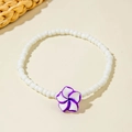 Detail of white beaded anklet featuring a resin frangipani flower for bohemian style - Purple Frangipani Style