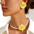 Nahaufnahme gelber Blumenohrringe und weißer Perlenkette an einem weiblichen Modell - Gelbes Blumenset (27720-EN-yellow-set)