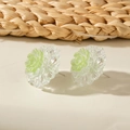 Detail shot of pastel 3D flower stud earrings with resin petals and green glitter center - Cyan
