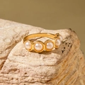 Elegant gold finish ring with five pearls set in a row on a natural rock background - Classic Vintage Row Ring (30419-ring-7)