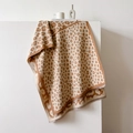 Beige leopard print shawl scarf with soft fringes displayed on a minimalist pedestal - Khaki