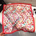Silk square scarf with red floral patterns and solid red borders on a plush surface - Red Pink (Botanical Print)