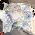 Elegant square silk scarf with blue lotus floral print draped on a black leather handbag - Azure (Hand-drawn Floral)