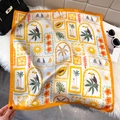 Tropical silk scarf with orange border and toucan motifs laid on a plush rug - Lemon Yellow (Summer Tropical)