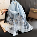 Light blue embroidered floral scarf in sheer fabric hanging against a dark background - 90*192cm / Blue
