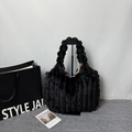Black faux fur tote bag with vertical stripes texture on a display stand - Black