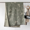 Detail of green maple leaf jacquard scarf with delicate fringe edges and soft texture - Green