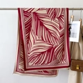 Detail of red and white leaf print scarf with tassels styled on a beige trench coat - Red (GSJ-349-Red)