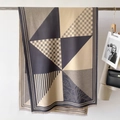 Detailansicht eines Schals mit geometrischem Muster, Fransen und moderner Stricktextur - Grau