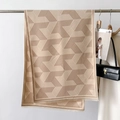 Detail of beige geometric scarf with fine fringe tassels hung next to a white wool coat - 66*186cm / Khaki