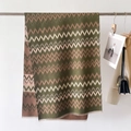 Dettaglio macro della sciarpa effetto cashmere con trama a zigzag e finitura a frange - Verde